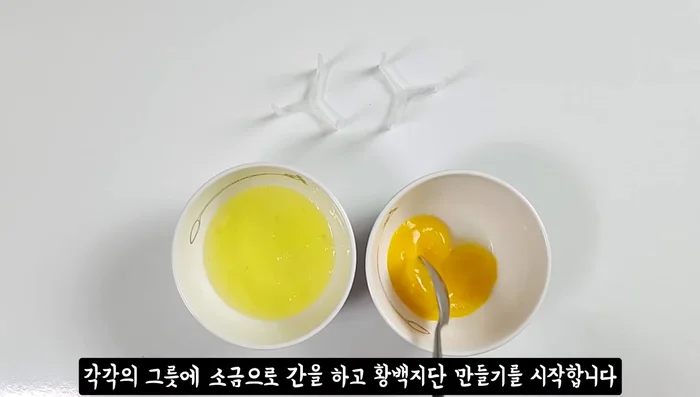 Prepare the jjidan (egg mixture): Crack two eggs, separate the yolks and whites. Season each with salt and cook them in a lightly oiled pan over low heat, then slice into even pieces.