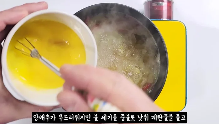 Once the cabbage is soft, lower the heat. Gently dissolve the egg into the soup, avoiding stirring until it sets.