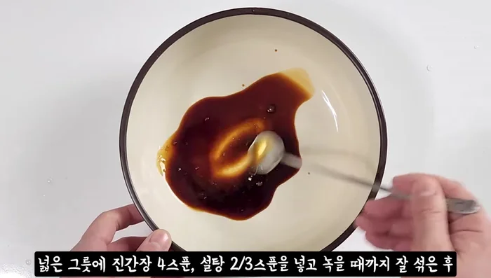 In a large bowl, mix 4 tablespoons of soy sauce and 2 tablespoons of sugar until dissolved.
