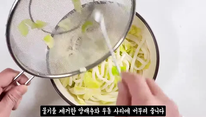 Add the drained cabbage and udon noodles to the soy sauce mixture.