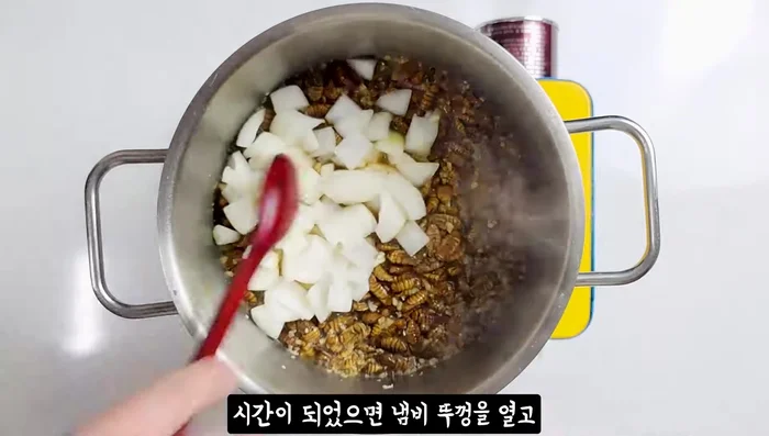 Add the onion, green onion, and 0.5 tbsp red pepper powder. Cook until pupae are seasoned.