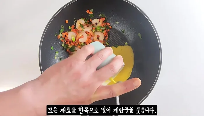 Push ingredients to one side, pour in the whisked eggs. Once fluffy, gather to the side.