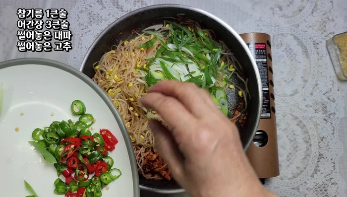 Add 1 tbsp sesame oil, 3 tbsp soy sauce, the sliced green onions, and peppers, and stir-fry for 2-3 minutes.