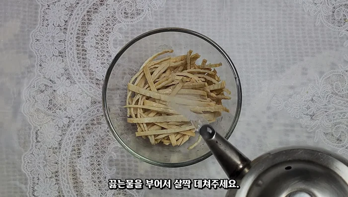 Cut the fish cakes into three thin strips, pour boiling water over them, and blanch slightly to remove excess oil and fishy smell.