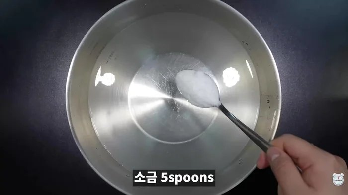Dissolve salt in water. Place a strainer over the bowl and add the clams.