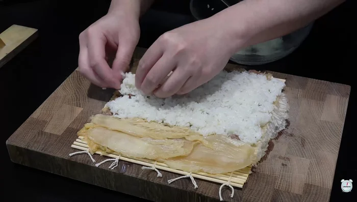 Spread the rice evenly on top and roll it up.