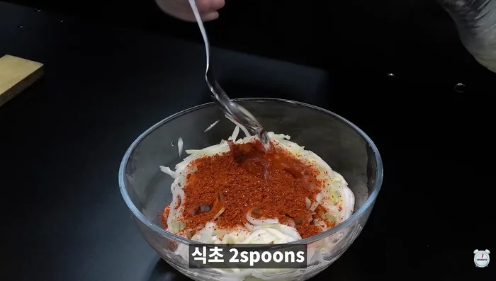 Drain the marinated pork. Add red pepper powder, vinegar, anchovy sauce, sesame oil, sesame seeds, green onions, and minced garlic. Mix well to make the radish salad (It's implied this is radish salad, the recipe doesn't specify).