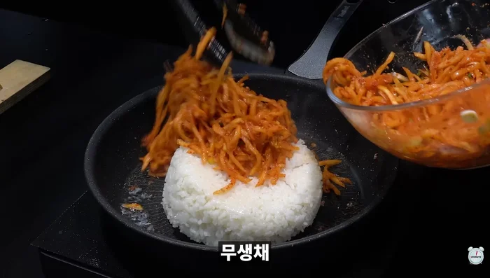 Put rice, some radish salad, and gochujang in a pan and fry.