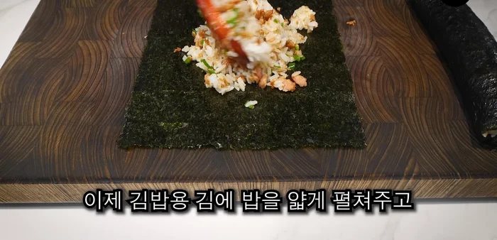 Spread the rice thinly on the kimbap seaweed sheets and roll them up.