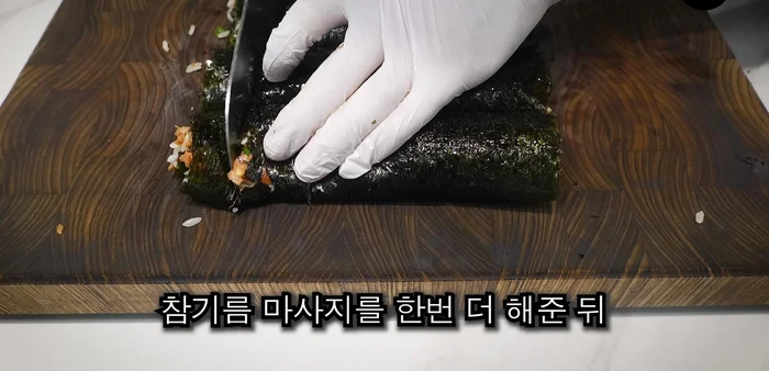 Massage the outside of the kimbap with sesame oil, cut into bite-sized pieces, and sprinkle with sesame seeds and mayonnaise.