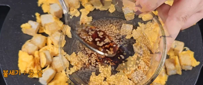 Gently mix the egg and tofu, leaving the center of the pan empty.