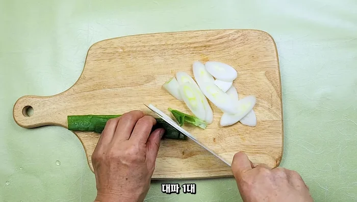 Prepare vegetables: Thinly slice green onion and kimchi.