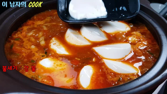 Add the drained soft tofu, green and red chili peppers, and an egg. Add enoki mushrooms if desired.