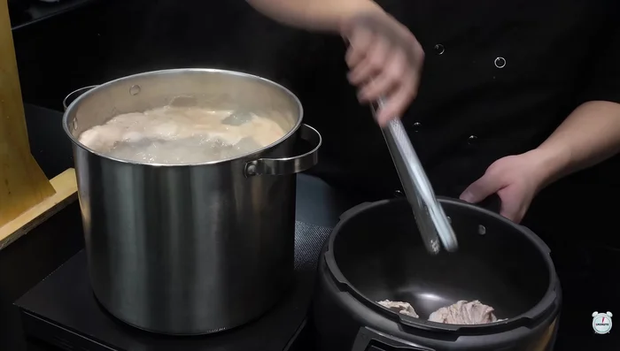 Move blanched bones to a pressure cooker. Add pressure cooker water, green chili pepper, soju, whole pepper, and ginger. Boil on high heat.