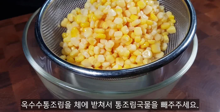 Strain the canned corn liquid using a strainer.