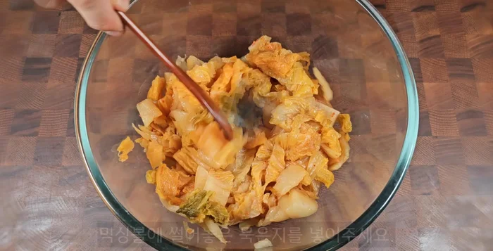 In a mixing bowl, combine the cut kimchi, 1.5 cups of sweet corn, 1.5 cups of pancake mix, 1 spoon of red pepper powder, and 2 cups (400ml) of water.