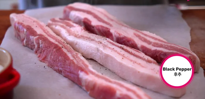 Prepare the pork belly: Season pork belly slices with salt and pepper. (165.519)