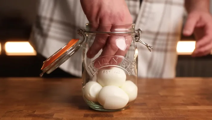 Place peeled eggs in a sterilized jar, pour marinade over to completely cover.