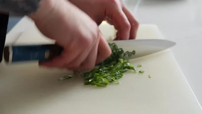 Prepare the toppings: Thinly slice red onion, green onion (on a bias), and Thai basil. Finely mince cilantro. Slice cabbage as thinly as possible.