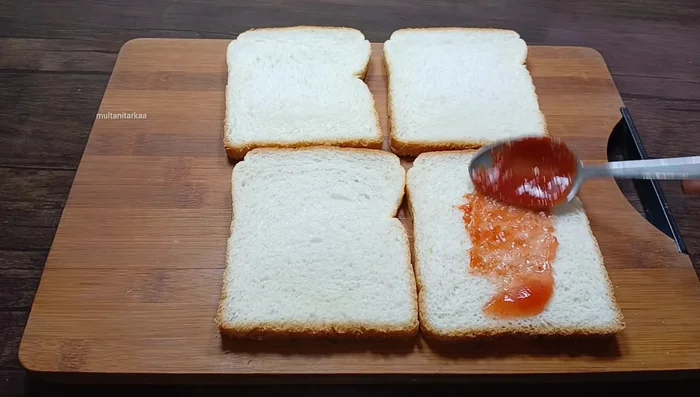 Spread ketchup or chili sauce on one side of each bread slice.