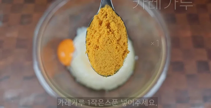 Add 1 teaspoon of curry powder and mix well with the rice and eggs, ensuring the rice is evenly coated.