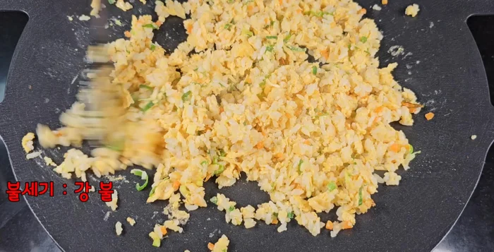 Stir-fry everything together over high heat until the rice is coated and separated, forming individual grains. Add sesame oil only after a faint curry scent is present.