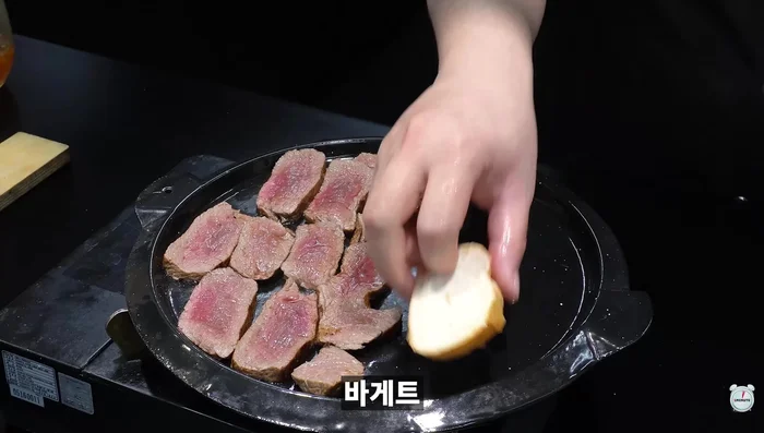 Put the hanni-sized steak pieces, baguette, and gunganni threads in the pan.