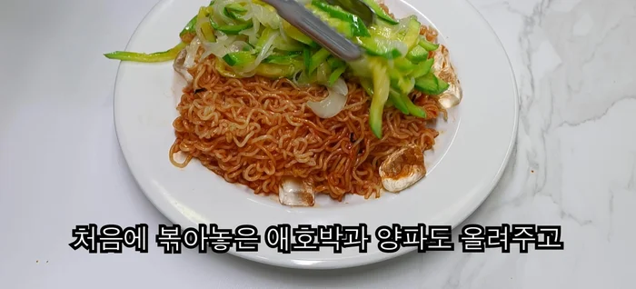Top the bibim noodles with the stir-fried mixture, chives, and sesame seeds.