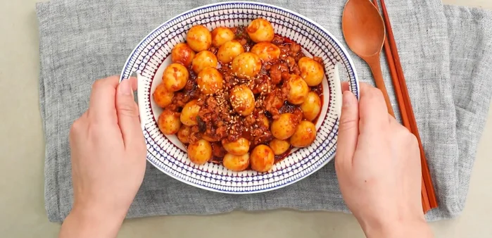 Toss the cooked quail eggs in the prepared sauce, ensuring they are evenly coated. (Specific instructions are missing from the transcript)