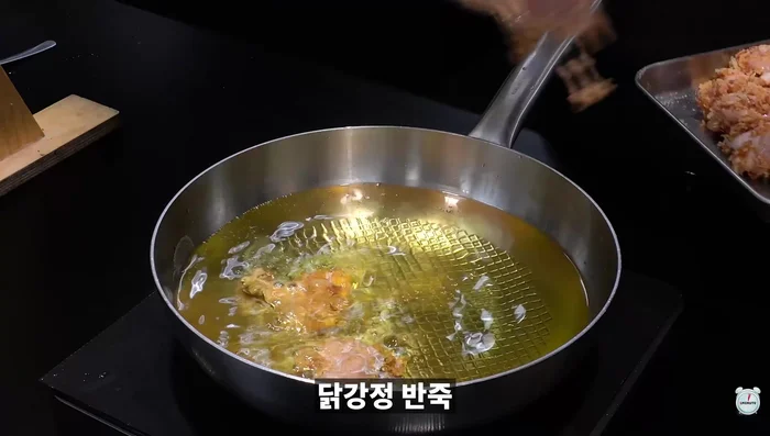 Pour cooking oil in a pan and fry the chicken gangjeong twice for extra crispiness.