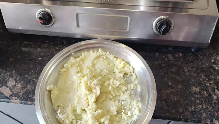 Mash the boiled potatoes well using a masher.