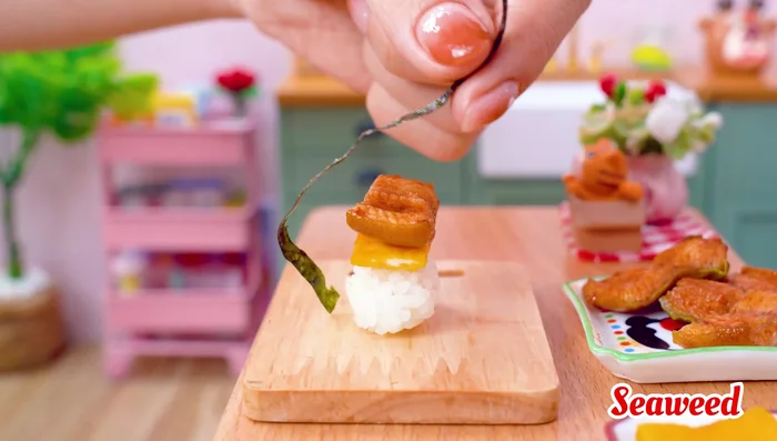 Assemble the sushi: Put egg and eel on seaweed; roll up.