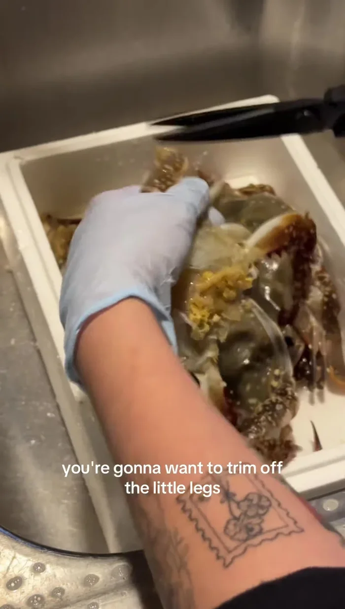 Clean the crab: Trim off the legs to allow the marinade to penetrate better. Remove the yellowish guts from the inside if desired.