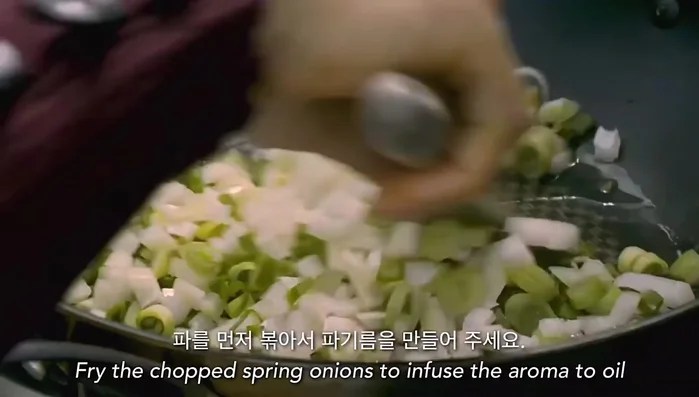 Fry the chopped spring onions in oil.