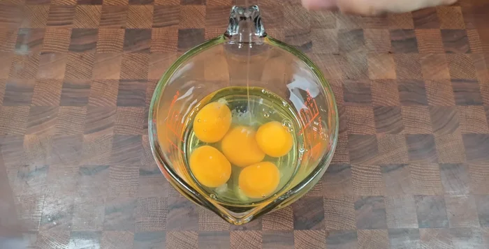 Crack and prepare five eggs. Add 1 teaspoon of seasoned salt, a spoonful of tuna liquid (to add flavor and remove fishy smell), and a spoonful of seasoned alcohol. Mix well.