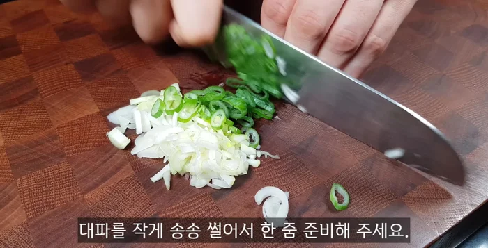Prepare green onions, cut into small pieces, separating the white and green parts. Prepare two creamy tofu and tear them into small pieces, separating the white and green parts.