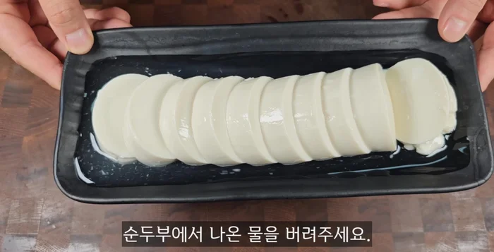 Pour out the water that drained from the soft tofu. Transfer the soft tofu to a microwave-safe bowl.