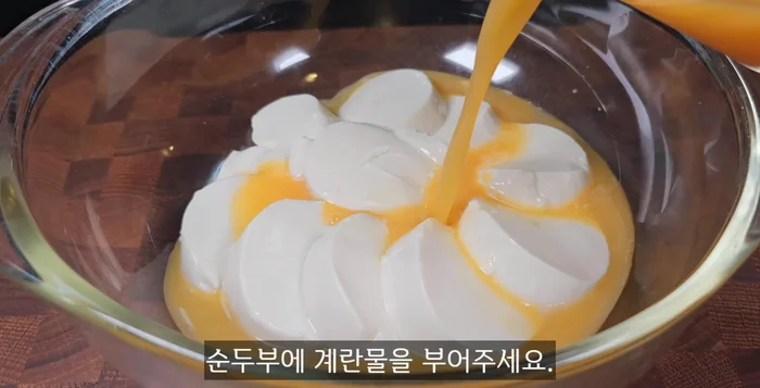 Pour the egg water over the soft tofu. Add the white part of the creamy tofu and the white part of the green onions.