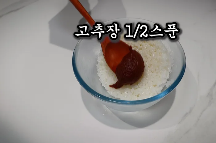 Add 1/2 spoon of spicy tuna paste and a small amount of sugar to the rice cake to balance the taste.