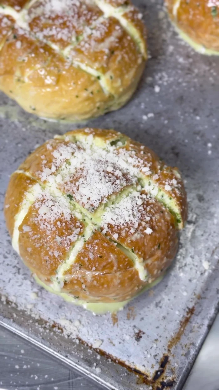 Assemble the bread: Cut the bread into eight pieces. Spread the cream cheese mixture onto the bread. Top with the garlic basil mixture and parmesan cheese.
