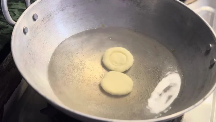 Boil the patties in hot water until they float to the surface, indicating they are cooked.