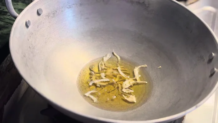 Heat oil in a wok. Add dry onion (or fresh onion) and saute until slightly roasted.