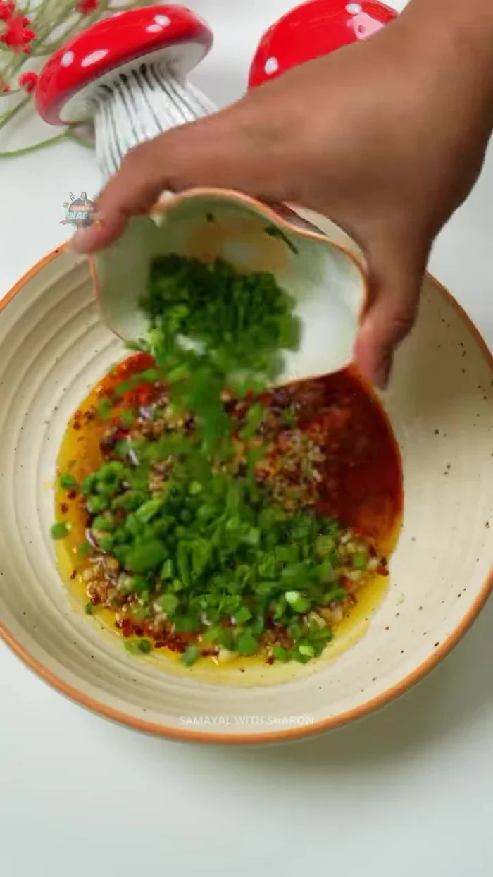 Optionally, heat mustard oil (or regular oil) and add it to the sauce. Add spring onions.