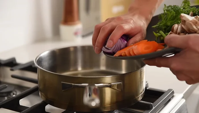 In a pan over medium heat, sauté red onions and carrots for 2-3 minutes.