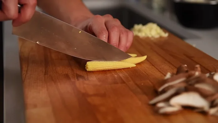 Slice four spears of baby corn in half.