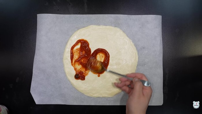 Lay the pizza dough on baking paper.