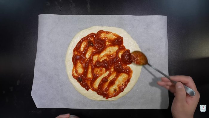 Spread tomato pasta sauce over the dough.