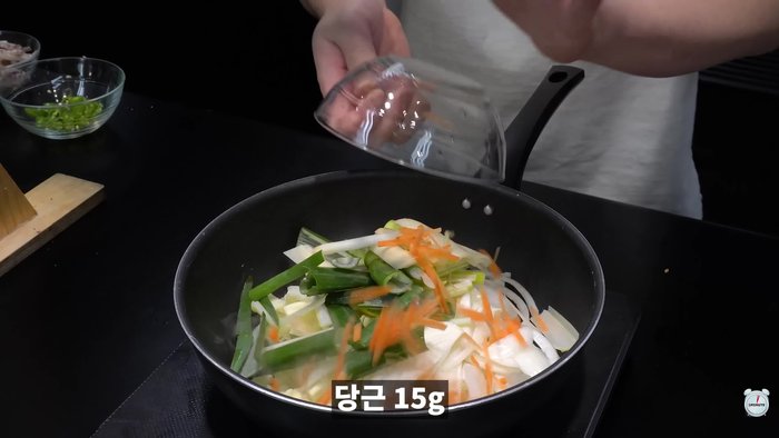 Stir-fry cabbage, onion, green onion, shredded carrot, fine red pepper powder, soy sauce, ramen flakes, and soup.