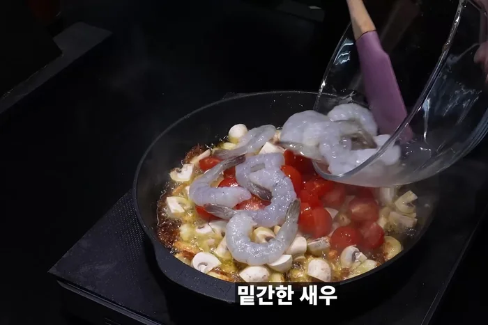 Cut onion into crosses and add to the pan along with cherry tomatoes, shrimp, and red pepper powder. Mix well.