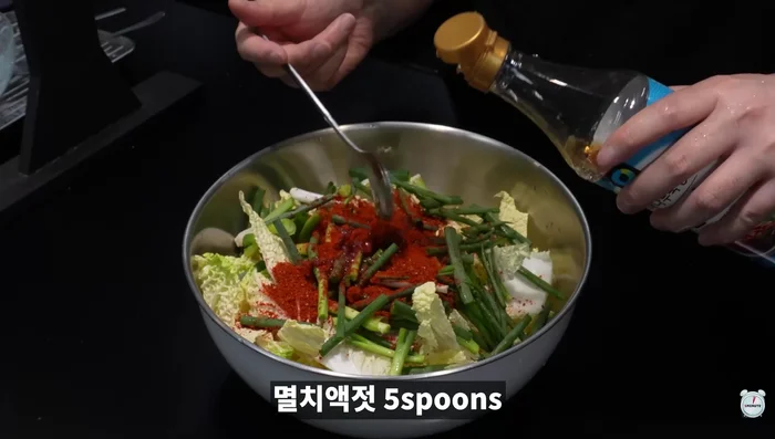 Prepare kimchi: Cut cabbage into bite-size pieces. Add green onions, red pepper powder, anchovy sauce, sesame oil, minced garlic, corn syrup or rice syrup (or oligosaccharide), sugar, sesame seeds, and seasoned salt. Add vinegar to taste.